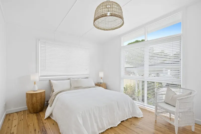 White bedroom with a rattan pendant light