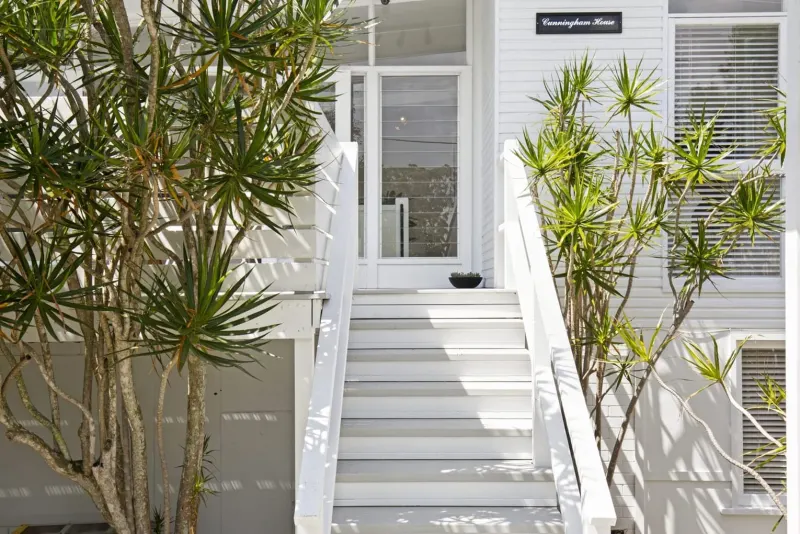 White front stairs and entry with palms