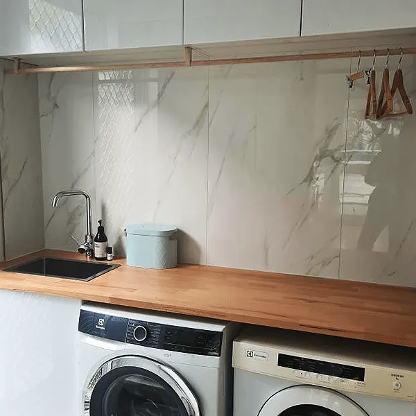 Laundry with a marble splashback and timber benchtop