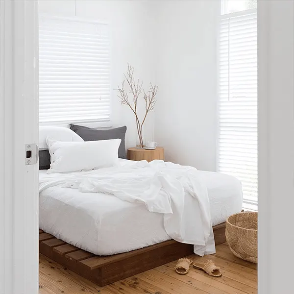 White bedroom with a timber bed base